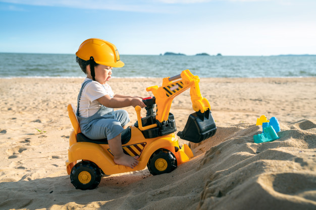 asian-boy-play-excavator-toy-beach_167657-168
